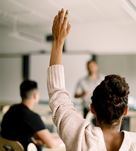 girl raising her hand in a classroom